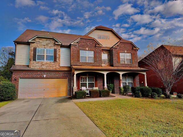 view of front of home featuring a garage, a front lawn, and covered porch