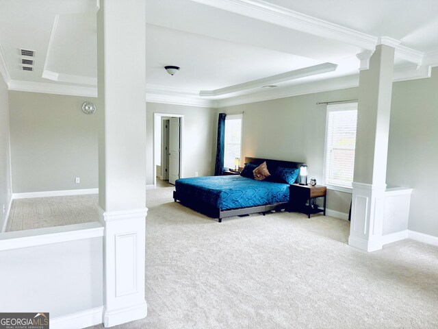 carpeted bedroom with ornamental molding, decorative columns, and a raised ceiling