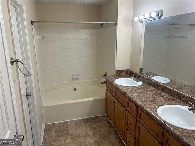 bathroom featuring tiled shower / bath combo and vanity