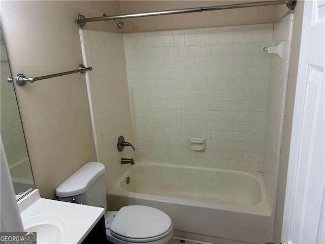 full bathroom featuring vanity, tiled shower / bath, and toilet