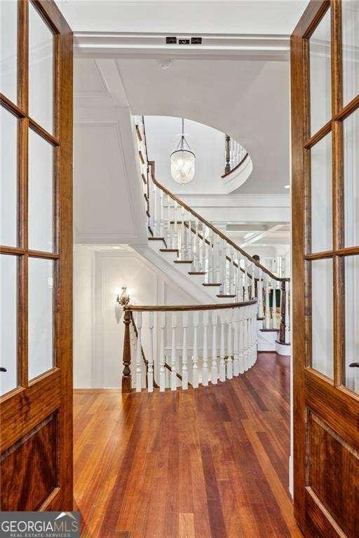 stairway with a notable chandelier and hardwood / wood-style flooring