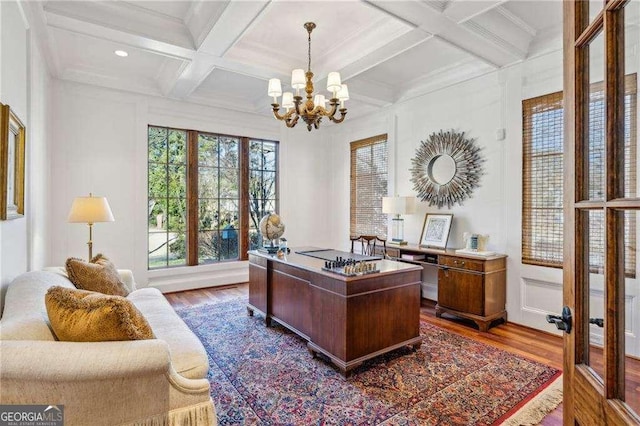 office space with an inviting chandelier, coffered ceiling, hardwood / wood-style floors, and beam ceiling