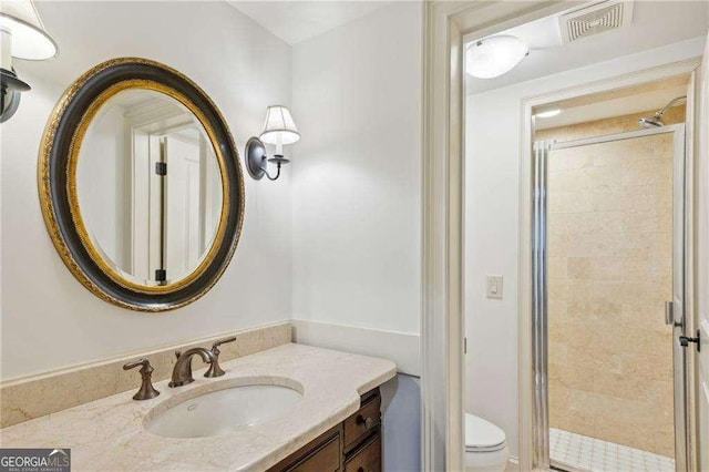 bathroom featuring vanity, an enclosed shower, and toilet