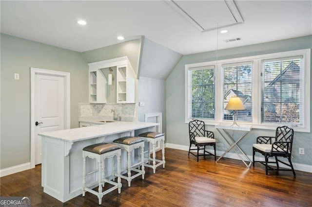 kitchen featuring plenty of natural light, sink, a breakfast bar area, and kitchen peninsula