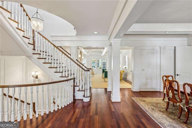 entrance foyer with ornamental molding, dark hardwood / wood-style flooring, and ornate columns