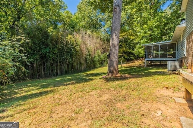 view of yard featuring central AC and a sunroom