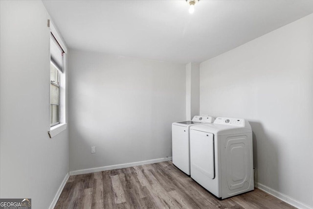 clothes washing area with light hardwood / wood-style floors and washing machine and clothes dryer