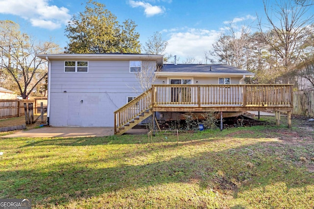 rear view of property featuring a wooden deck, a yard, and a patio