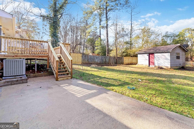 view of yard featuring a deck, central AC unit, a patio area, and a shed