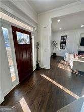 entryway with dark wood-type flooring and crown molding