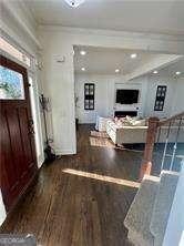 entryway featuring crown molding and dark hardwood / wood-style floors