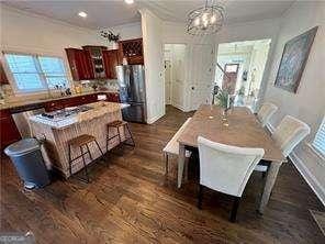 dining area with an inviting chandelier and dark hardwood / wood-style floors