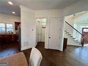 interior space with crown molding, dark wood-type flooring, and multiple windows