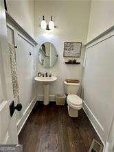 bathroom with hardwood / wood-style flooring and toilet