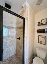 bathroom with toilet and a tile shower