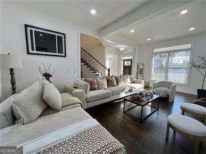 living room featuring beamed ceiling and dark hardwood / wood-style floors