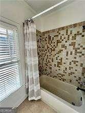 bathroom featuring shower / tub combo and plenty of natural light