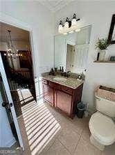 bathroom featuring vanity, tile patterned flooring, toilet, and an inviting chandelier