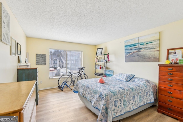 bedroom featuring a textured ceiling and light hardwood / wood-style floors