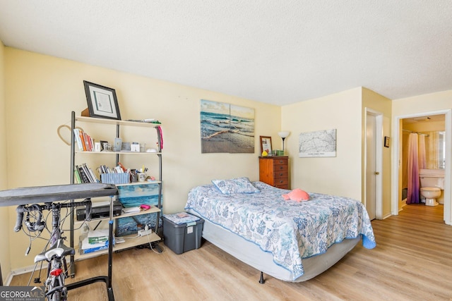 bedroom featuring light hardwood / wood-style flooring and a textured ceiling