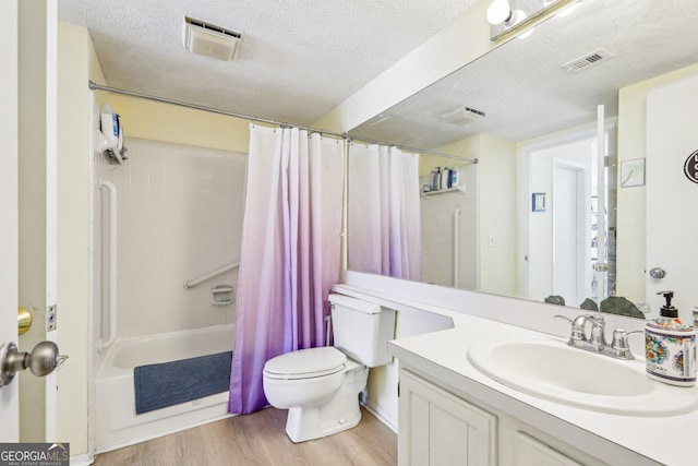 full bathroom featuring hardwood / wood-style floors, vanity, shower / tub combo, toilet, and a textured ceiling