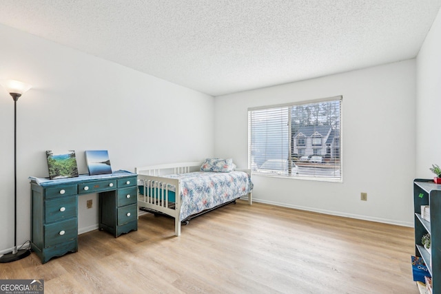 bedroom with light hardwood / wood-style flooring and a textured ceiling