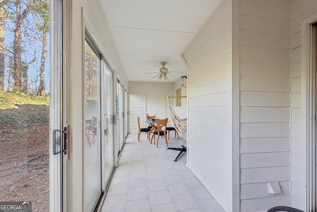 unfurnished sunroom featuring ceiling fan