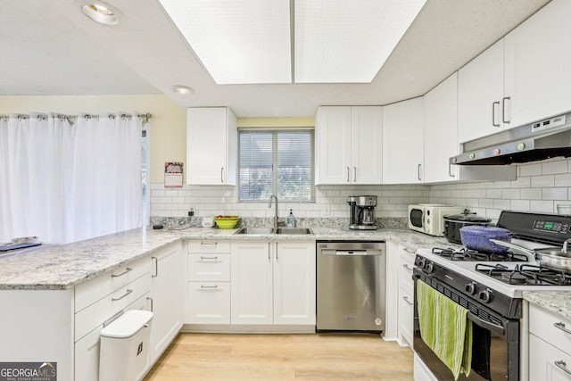 kitchen featuring sink, white cabinetry, range with gas cooktop, stainless steel dishwasher, and kitchen peninsula