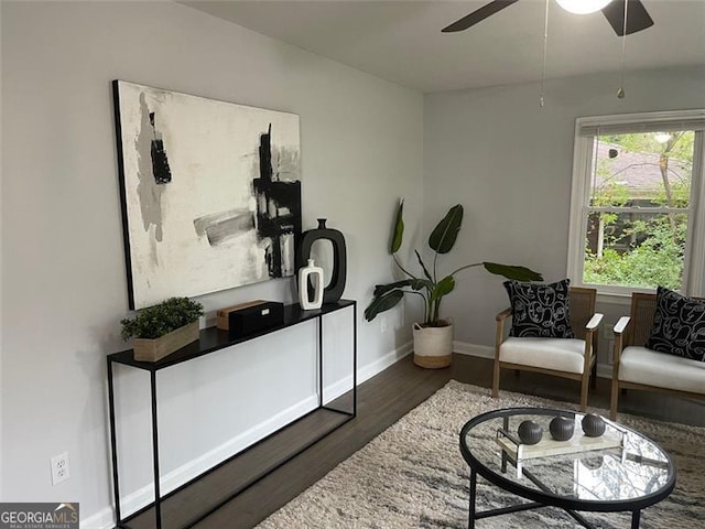 sitting room featuring dark hardwood / wood-style floors and ceiling fan