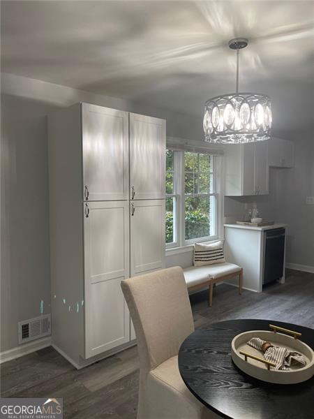 unfurnished dining area featuring dark hardwood / wood-style floors and a chandelier