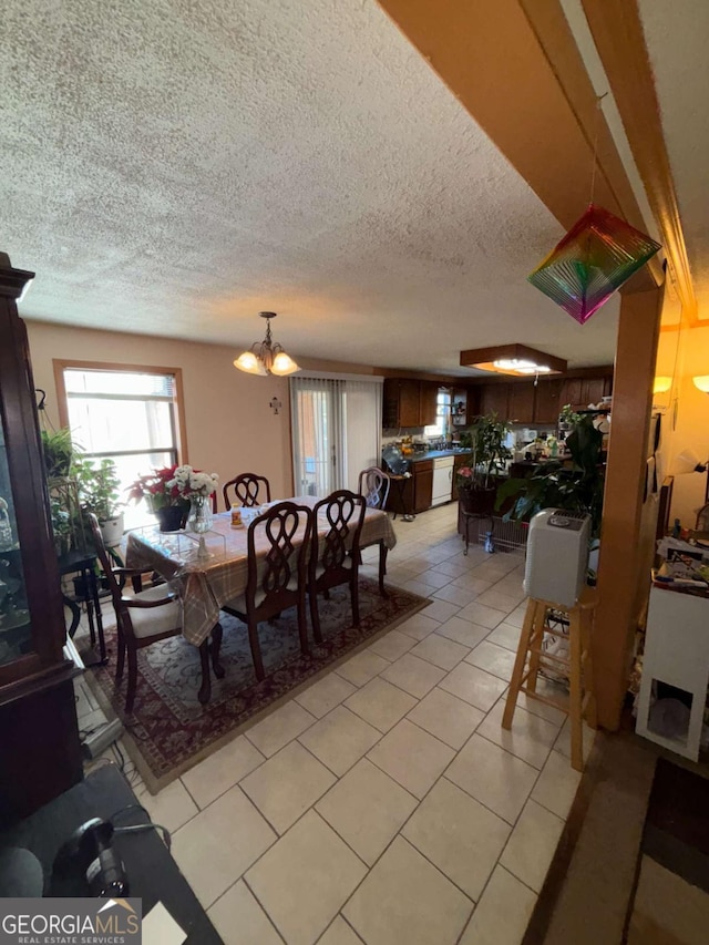 dining space featuring light tile patterned flooring, a textured ceiling, and a notable chandelier