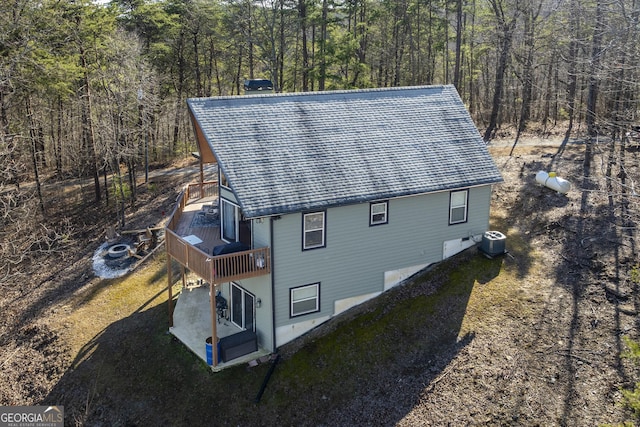 view of side of property featuring central AC unit, a patio, and a wooden deck