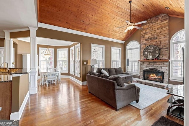 living room featuring ornamental molding, a wealth of natural light, light hardwood / wood-style flooring, and wooden ceiling