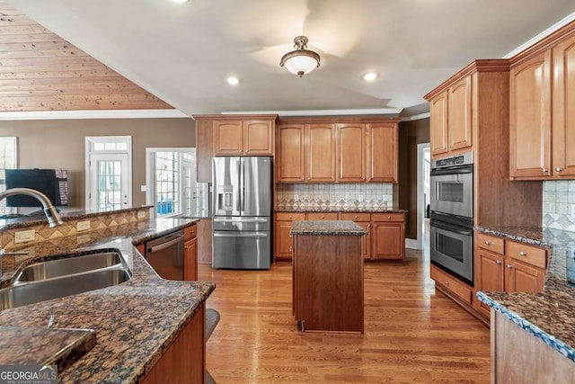 kitchen featuring sink, dark stone counters, and appliances with stainless steel finishes