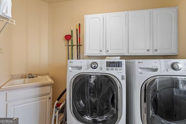 laundry area with sink, washer and clothes dryer, and cabinets