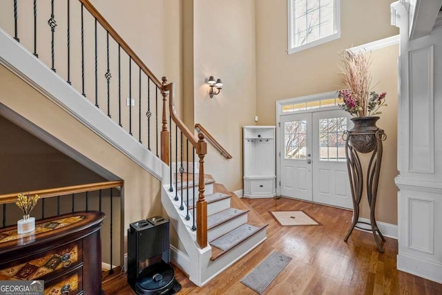 entryway with hardwood / wood-style floors, french doors, and a high ceiling