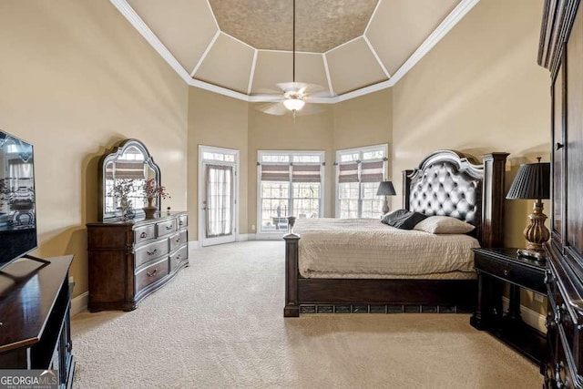 bedroom featuring crown molding, access to outside, ceiling fan, a tray ceiling, and light colored carpet