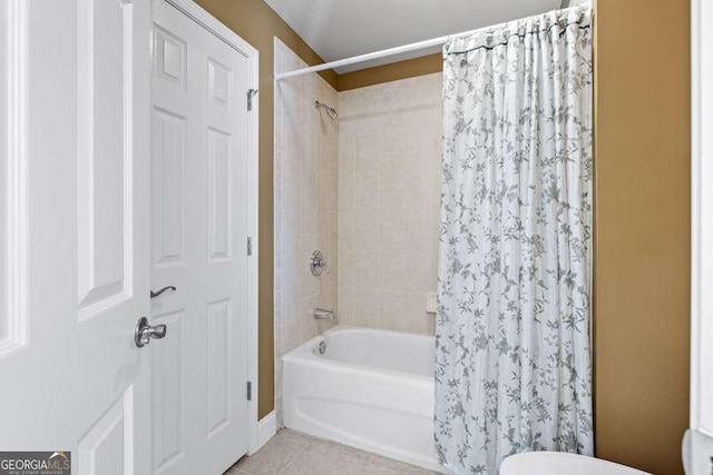 bathroom with shower / tub combo with curtain, toilet, and tile patterned flooring