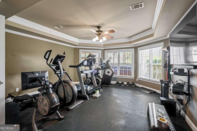 workout room with ornamental molding, a raised ceiling, and ceiling fan