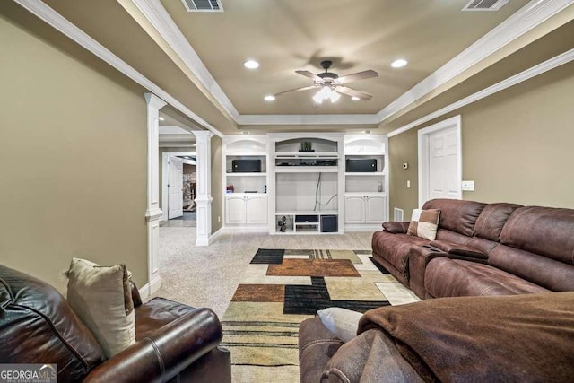 carpeted living room featuring crown molding, a tray ceiling, decorative columns, and ceiling fan