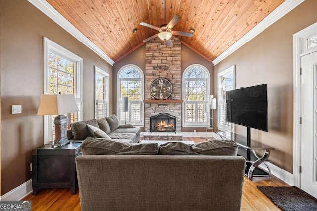 living room with a fireplace, light hardwood / wood-style flooring, ornamental molding, and wooden ceiling