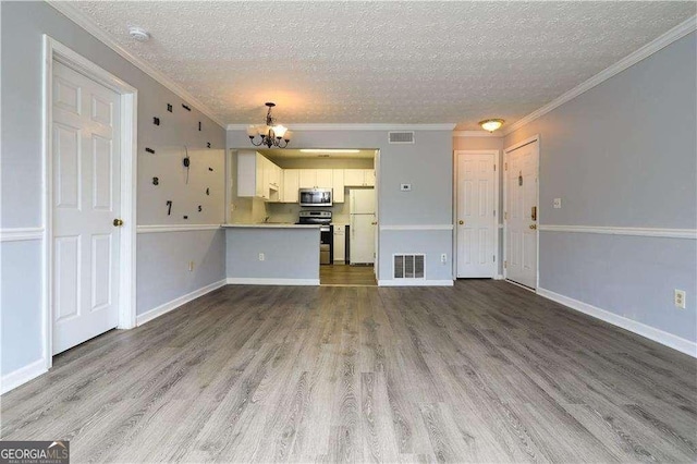 unfurnished living room featuring an inviting chandelier, light hardwood / wood-style flooring, ornamental molding, and a textured ceiling