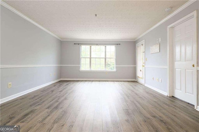 empty room featuring ornamental molding, dark hardwood / wood-style flooring, and a textured ceiling