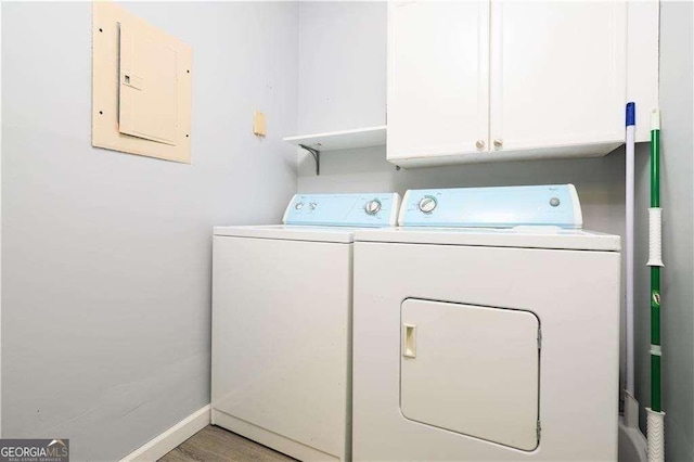 laundry area featuring washer and clothes dryer, electric panel, and cabinets