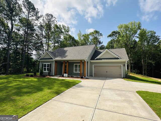 25 Patterson Dr, Franklin, GA 30217 - ranch-style house featuring concrete driveway, an attached garage, a front yard, and covered porch