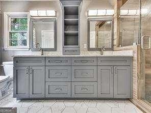 bathroom with a shower with door and vanity