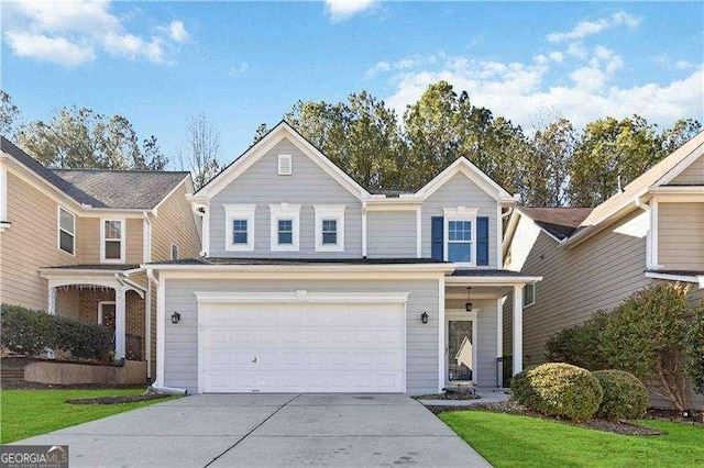 view of property featuring a garage and a front lawn