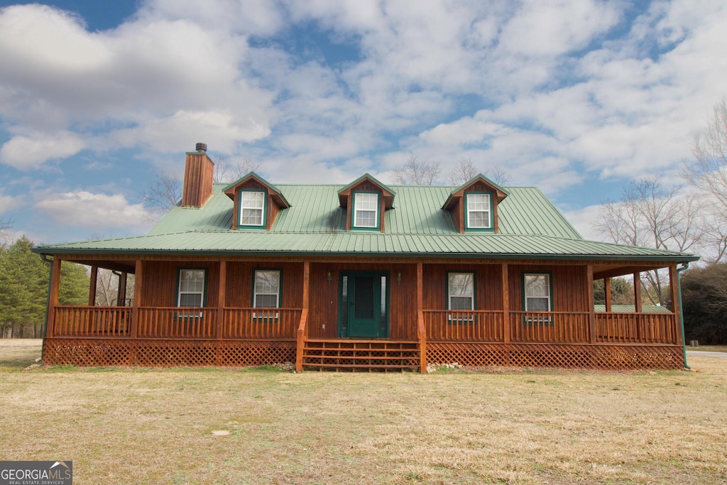 country-style home with a front yard and covered porch