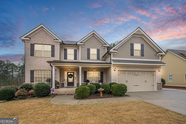 craftsman-style house featuring a garage, a yard, and covered porch