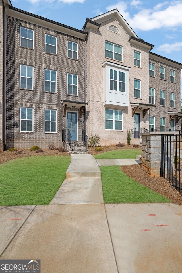 townhome / multi-family property featuring a front yard